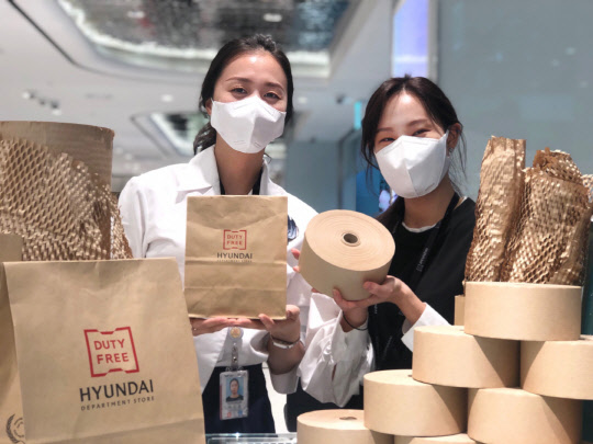 현대백화점면세점 직원들이 면세품 포장에 사용할 종이포장재를 소개하고 있다. 현대백화점면세점 제공